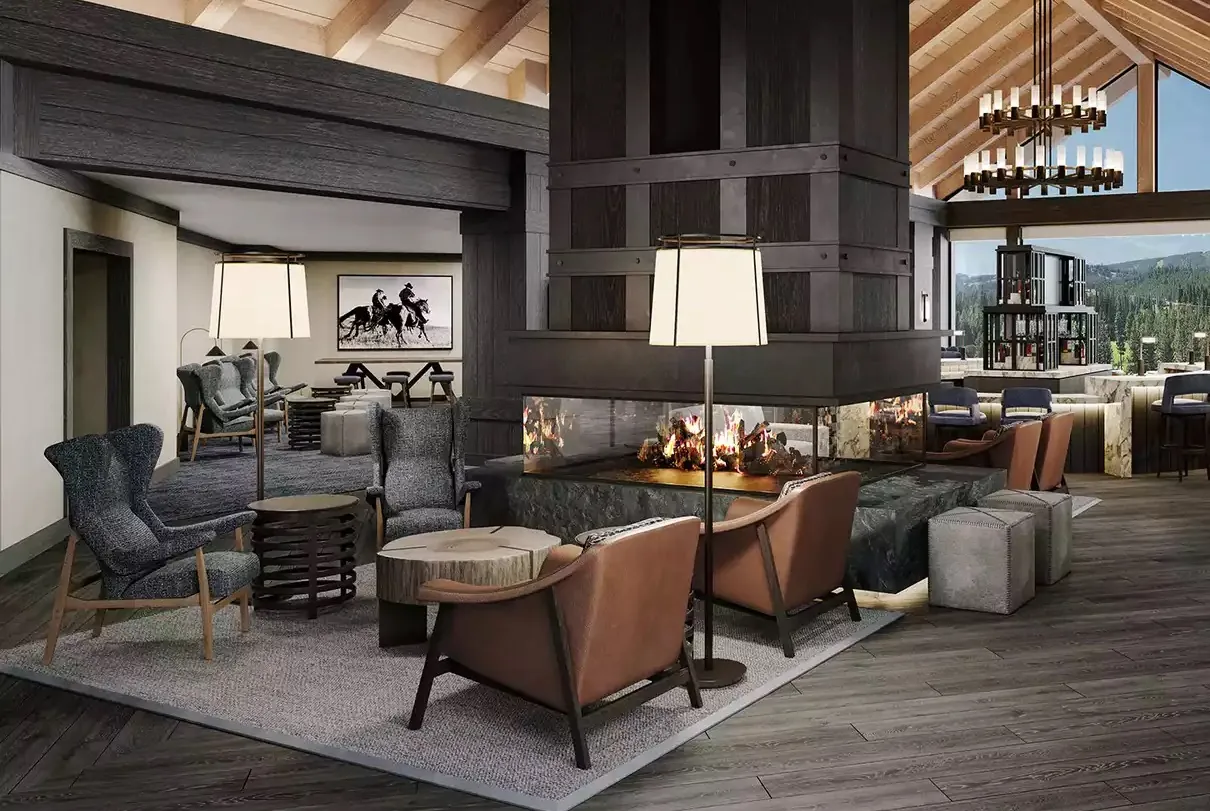 A hotel lobby lounge with leather armchairs around a double-sided fireplace