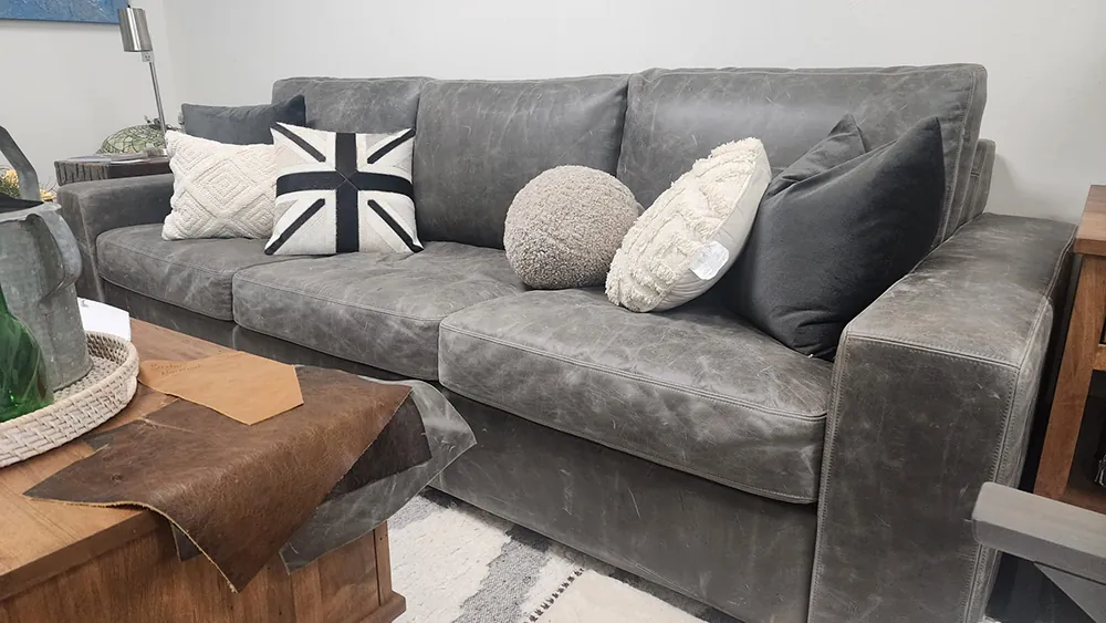 A grey leather sofa with patterned cushions